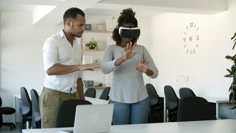 Excited-woman-testing-VR-headset-with-assistant